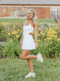 White Crisscross Luxe Active Dress by Arena Graffiti, showing a stylish athletic dress with crisscross details on the front.